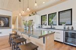 Large island with concrete countertop and seating for four
